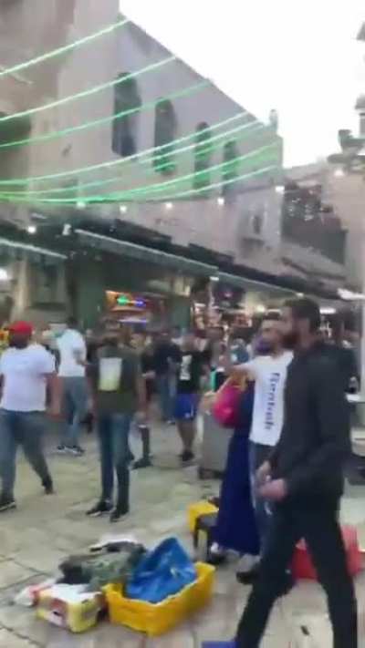 Israeli military terrorizing Palestinian civilians with weapons in Jerusalem market and throwing flash bangs at women and children.