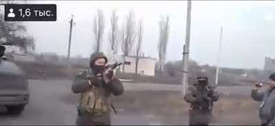 Defiant Ukrainian crowd singing and not backing off despite Russian soldiers firing warning shots