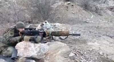 Maxim with a suppressor, scope, stock, biopod and camo.