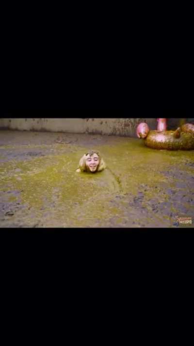 German girl swims in a pool of elephant shit