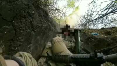 Ukrainian soldiers holding out in a trench while a hostile tank fires a projectile towards them, Donetsk region