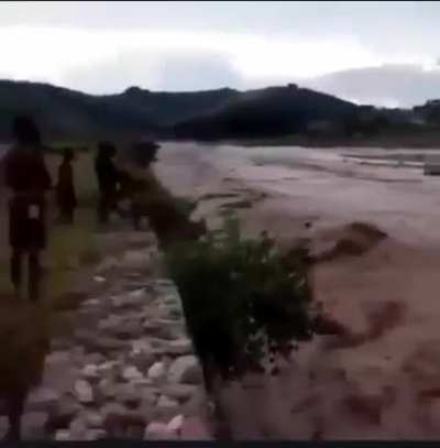 Indonesian children jumping in a flooded river.