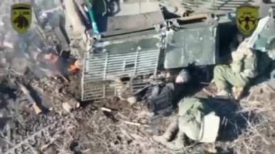 Ukrainian drone drops a munition on Russian soldiers hiding next to an abandoned vehicle