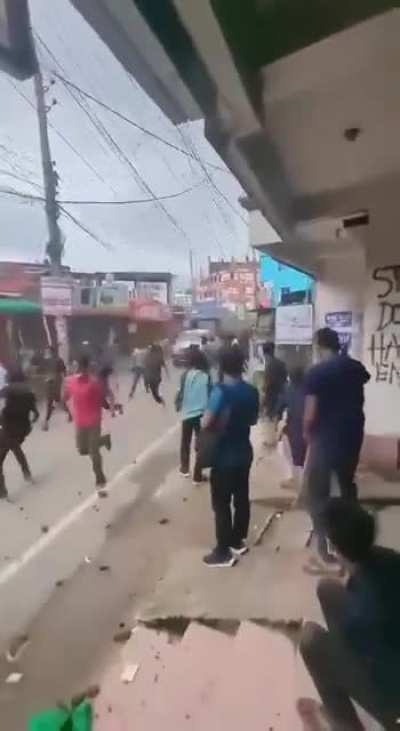 Bangladesh Police driving a vehicle through protesters.
