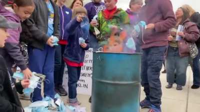 Parents of the year at the Idaho State Capitol building encouraging their kids to reach and grab used masks in a "mask burning RALLY", not a protest.