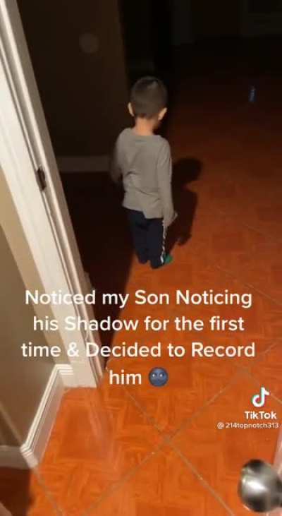 Kid noticing it's shadow.