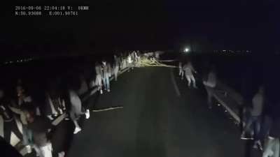 Migranți pașnici ur&acirc;ndu-le șoferilor de tir "Drum plăcut"