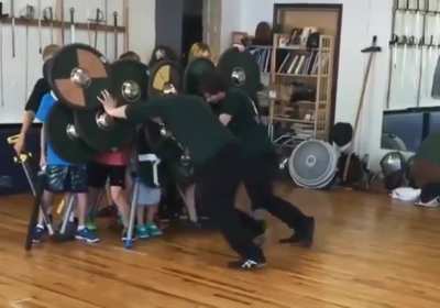 Group of students learning the strength of a proper shield wall