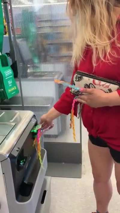 Woman struggles to use self checkout because of her extremely long nails getting in the way