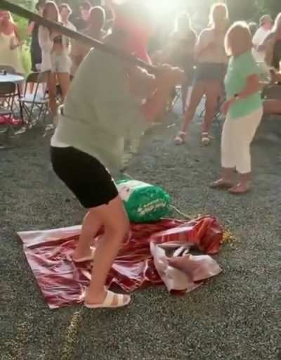 Standing in front of a blindfolded person trying to hit a pi&ntilde;ata