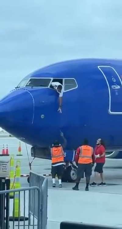 Ground staff help return a passenger&rsquo;s phone found near the gate after the plane had closed its door
