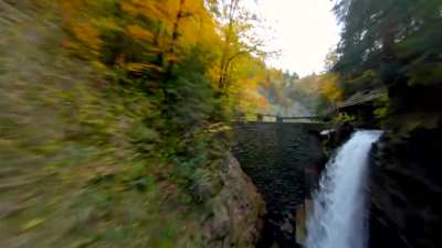 Flying under a bridge into a gorge