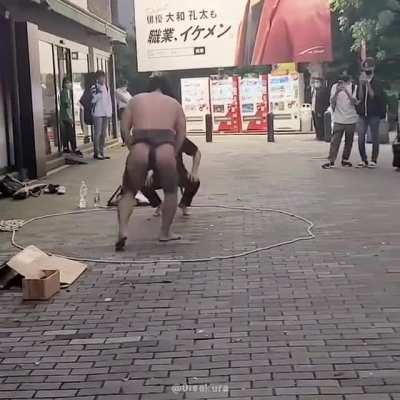 Sumo wrestling in the streets of Shinjuku, Tokyo, 2022. Osumosan against what it looks like an average passerby...