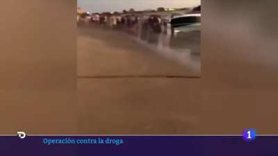 Beach-goers in Spain try to steal the drugs straight from a narco boat while the police attempts to stop them