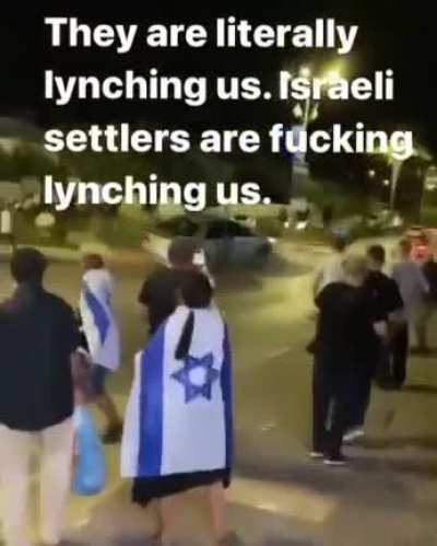 Isra*li Settlers blocking the road and lynching Palestinians who drive by them.