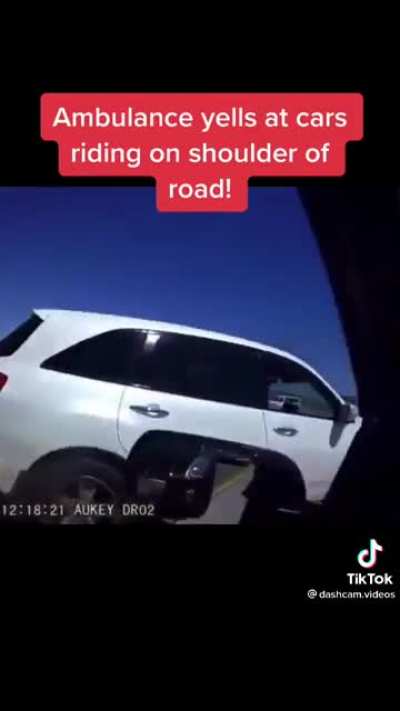 ambulance yells at cars on shoulder in traffic