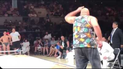 Sumo wrestler is disqualified for celebrating after a win, his coach protests and is removed by security.