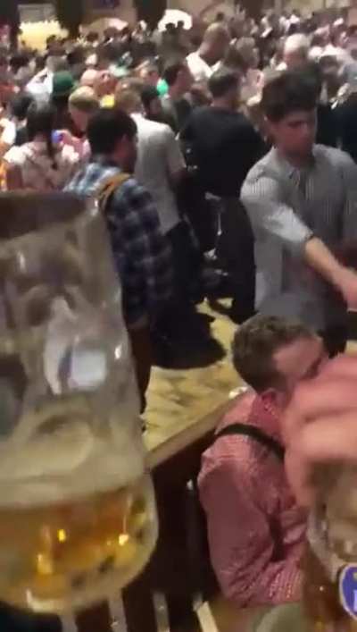 man pisses on floor at oktoberfest, hitting another man&rsquo;s leg and making a bar-maiden slip and eat piss