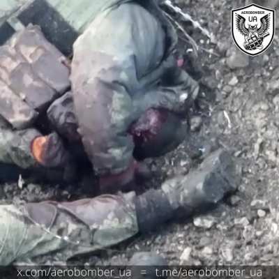 Mangled russian fondles his dead buddies leg and plays with some razor wire.