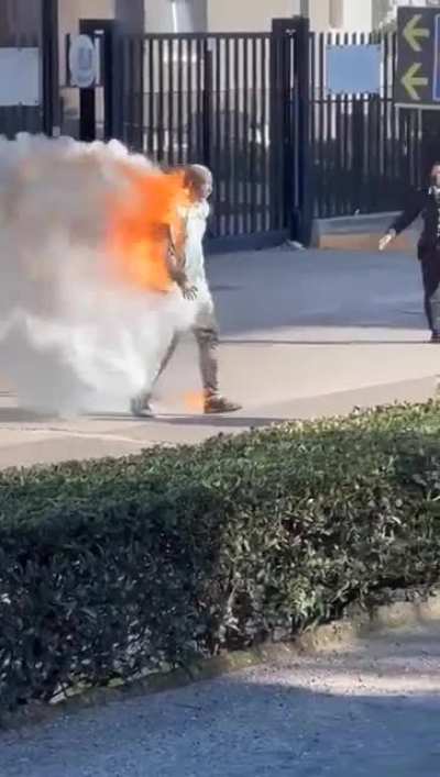 Burnin man in front police station