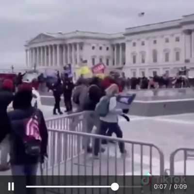 Police officer waving in the MAGA terrorists.. hurry hurry!!