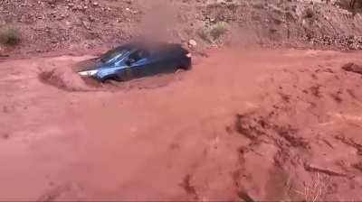 Family stuck from flashflood while dad records another vehicle floating down in flood with people still in it.