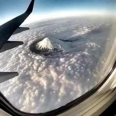 Amazing airborne view of rolling clouds around mt. Fuji, Japan