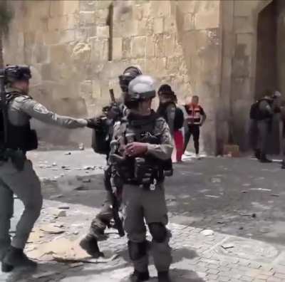 A journalist caught an Israeli soldier about to throw what looks like a smoke grenade at Medics and Journalists but he stopped when she caught him on camera.