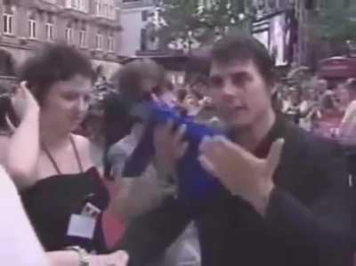 Tom Cruise gets squirted with water by a fan with a fake microphone