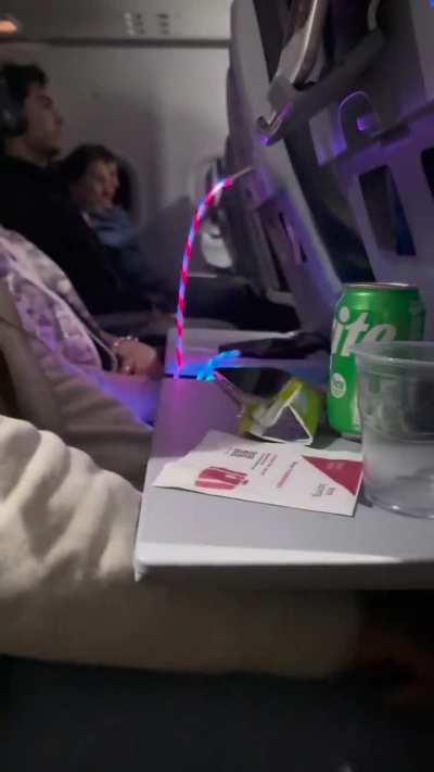 This woman&rsquo;s charger in my row during a 6+ hour red eye flight