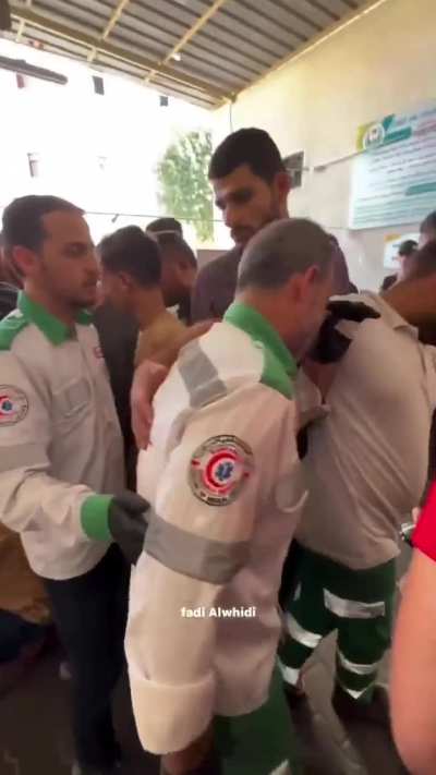 A Palestinian paramedic bids farewell to his son killed by "Israeli" bombing