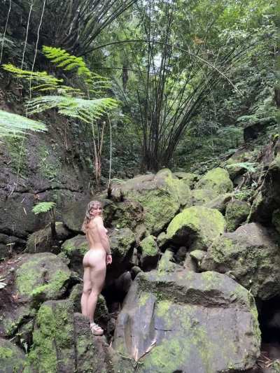 Curvy girl flashing in lush jungle rocks