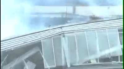 Idiot standing on top of a exploding building.