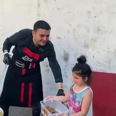 Man cooks a large amount of food and give to the people especially the poor and also the homeless person.