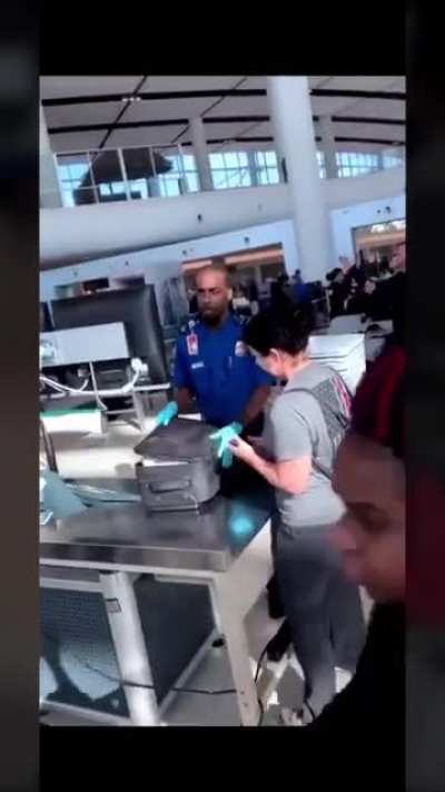 TSA agent opening the lady&rsquo;s bag and finding a giant dildo