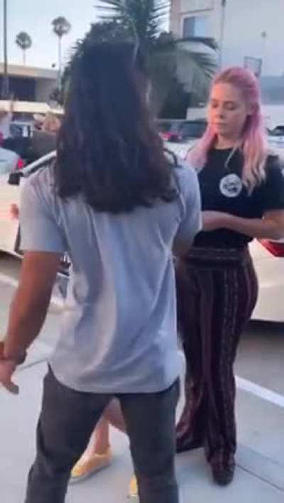 Guy eats burger next to vegan protesters.
