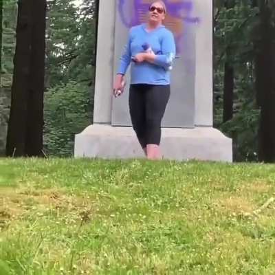 Lady that is furious a statue of a white man was replaced by a black man spray paints prince logo on it.