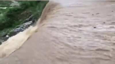 Man attempts to run across stream, meets waterfall