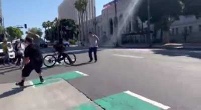 Anti-LGBTQ protestor gets chased away &amp; shoved by a ghost after throwing a water bottle at pro-LGBTQ protesters (Los Angeles).