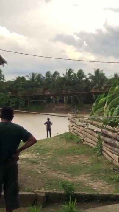 WCGW crossing a bamboo bridge with a motorcycle on a windy day