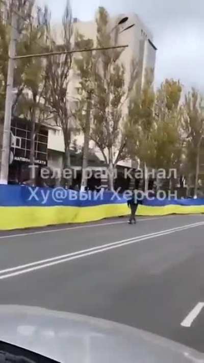 Kherson residents rolled out the huge blue and yellow Ukrainian flag - the one they came out to "greet" Russians with.