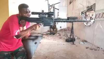 Sudanese soldier with an anti-materiel rifle and a machinegun firing on RSF forces