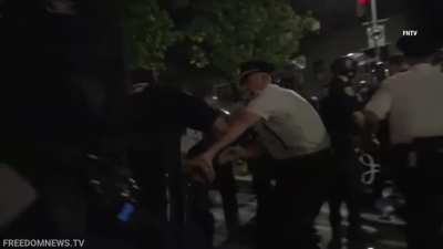 Police arrest anti-Trump protesters while people continue eating food - Manhattan, New York 26th September